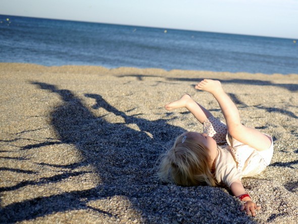 At lege og boltre sig på stranden en lun aften, hvor solen er tæt på at gå ned.